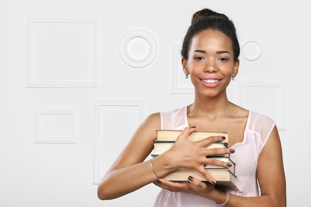 African american woman holding a pile of books