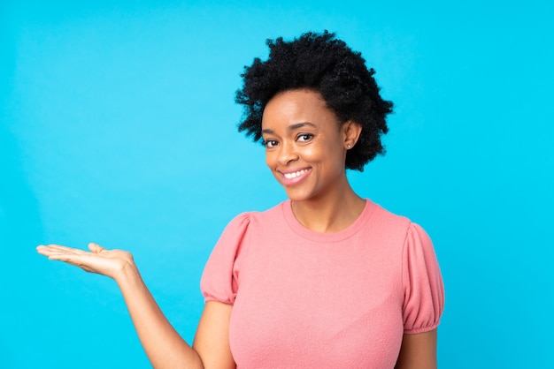 African american woman isolated holding copyspace imaginary on the palm