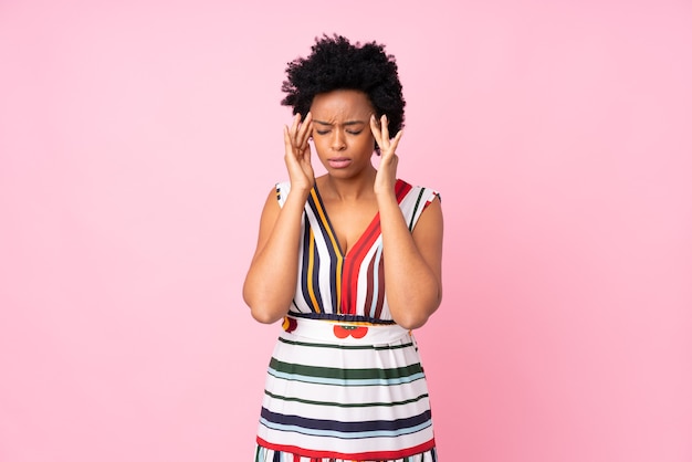 African american woman on isolated pink with headache