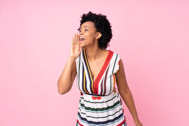 African american woman isolated shouting with mouth wide open to the lateral