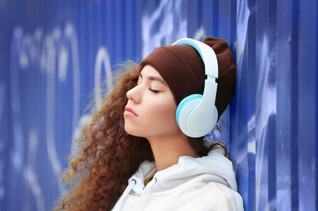 African American woman listening to music in headphones in the street