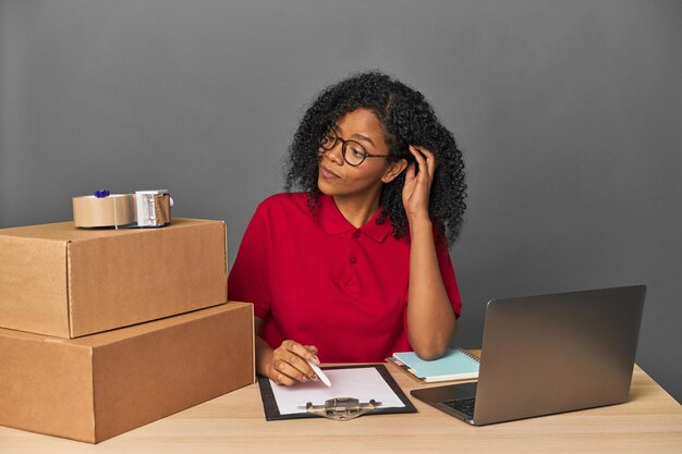 African American woman in logistics office with packages