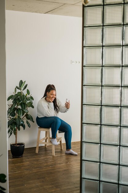 African american woman making video call in living room  social networks and connection