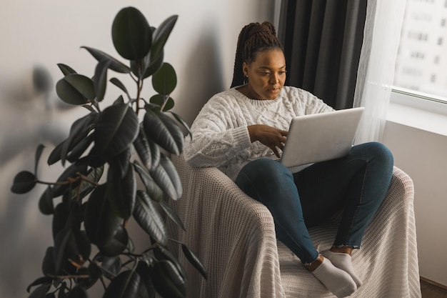 African american woman making video call in living room social networks and connection