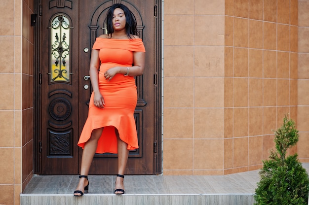 African american woman model xxl in orange dress.