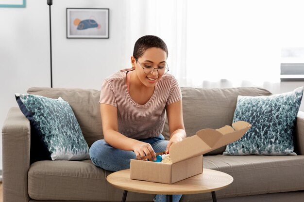 african american woman opening parcel box at home