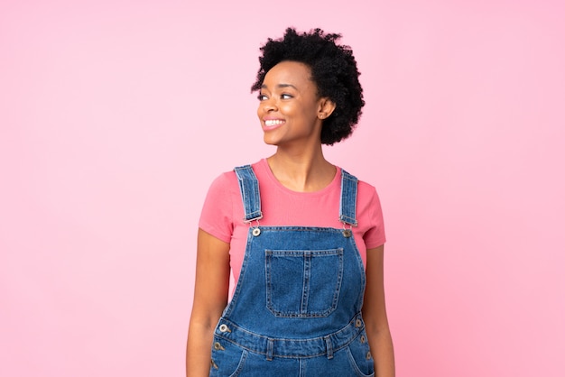 Donna afroamericana sopra la parete rosa