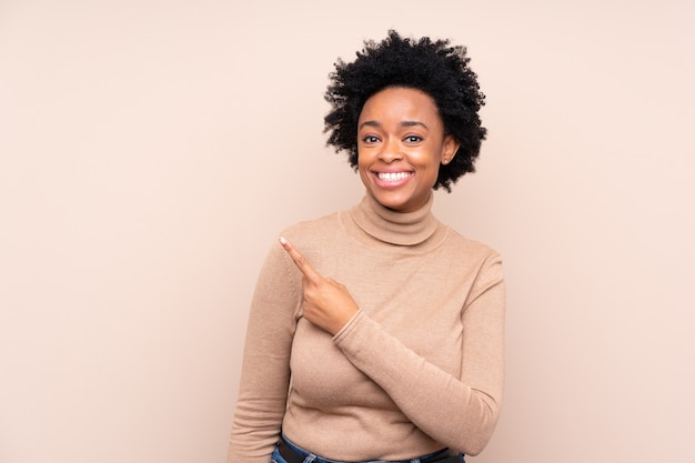 African american woman pointing to the side to present a product