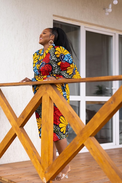 African american woman relaxing and enjoying sun while standing at terrace or balcony at sunlight at