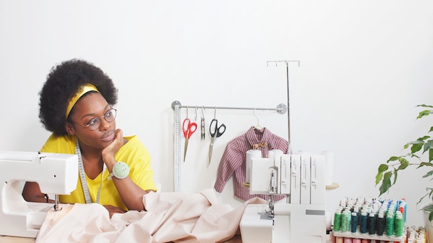 African-american woman sews clothes in her favorite studio, workshop