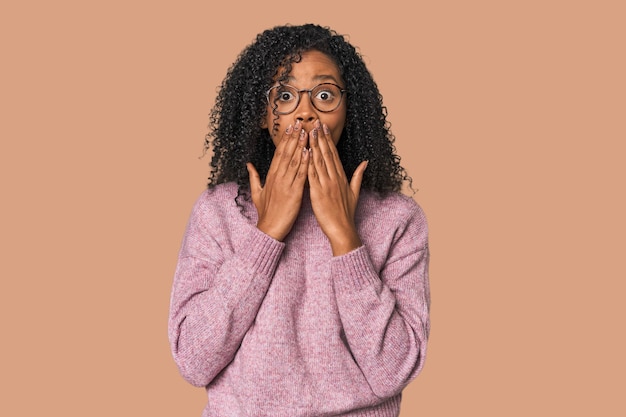 African American woman shocked covering mouth with hands anxious to discover something new