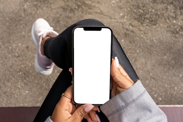 African American woman sitting in park with a mobile phone