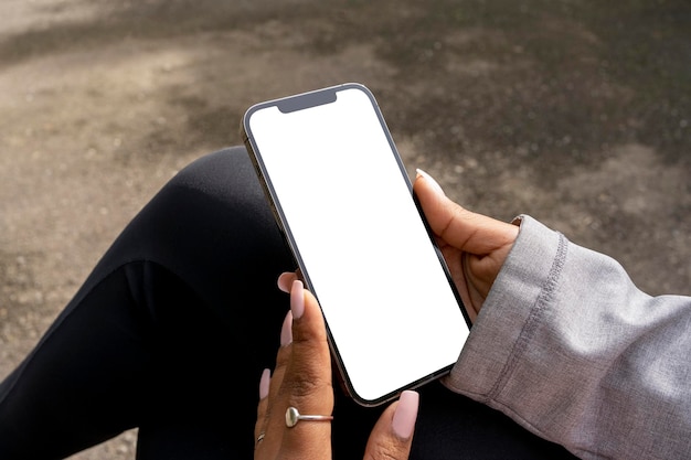 Photo african american woman sitting in park with a mobile phone