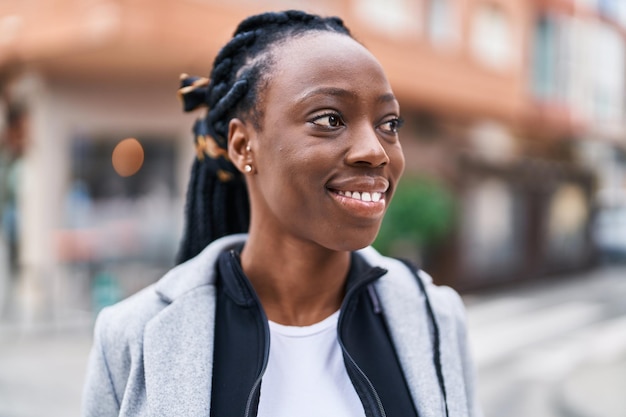 Африканская американка уверенно улыбается, глядя в сторону на улицу