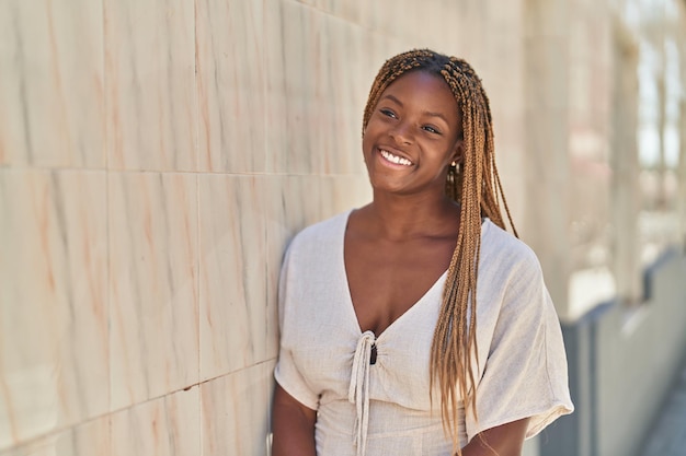 アフリカ系アメリカ人女性が自信を持って通りを横に見て微笑む