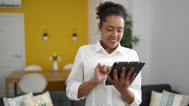 African american woman smiling confident using touchpad at home