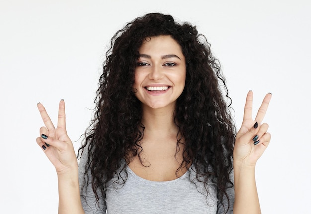 African american woman smiling looking to the camera showing fingers doing victory sign