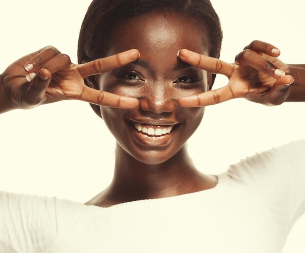 african american woman smiling looking to the camera showing fingers doing victory sign