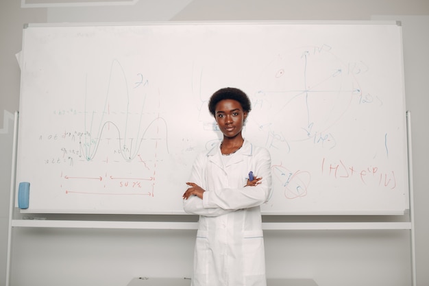 African American woman stand at whiteboard with formula and graph chart