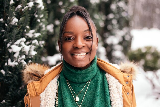 African american woman standing street outside near Christmas Tree, smiling, looking at the camera