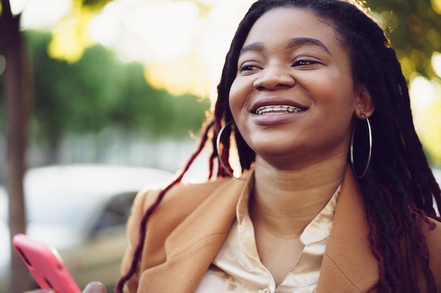 African american woman standing in a street and using smartphone