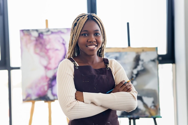 African american woman student in art class inspired and painting