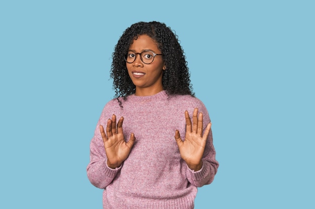 Foto donna afroamericana in studio che respinge qualcuno mostrando un gesto di disgusto