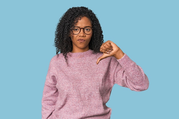 African American woman in studio setting showing thumb down disappointment concept