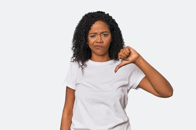 African American woman in studio setting showing thumb down disappointment concept