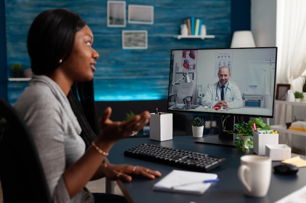 African american woman talking to medic on video call to
receive medical advice about telemedicine and telehealth at home.
young patient using online remote conference to talk to
physician