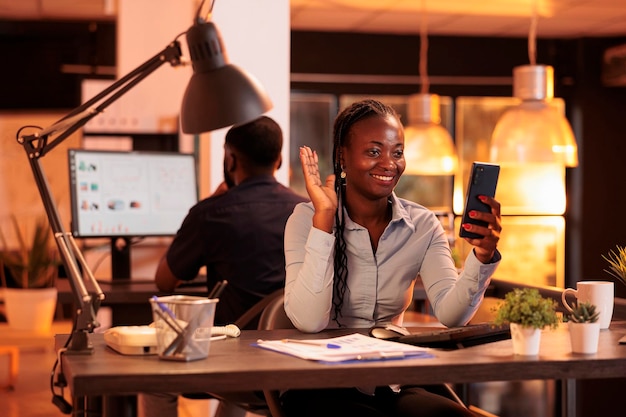 African american woman using remote videocall conference to talk to business people about corporate paperwork. Chatting on online teleconference call meeting, video telework on webcam.