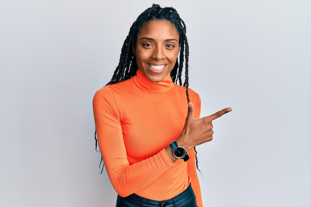 African american woman wearing casual clothes smiling cheerful pointing with hand and finger up to the side