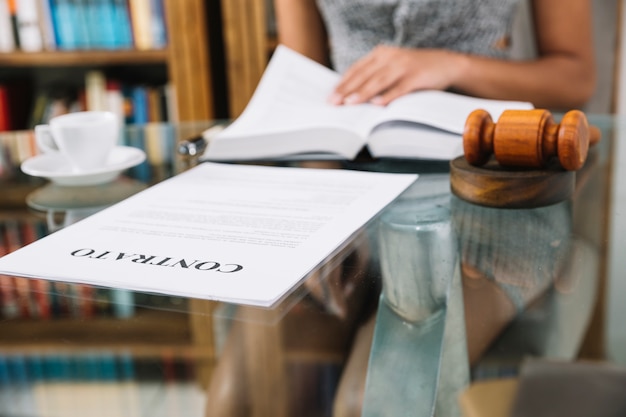 African american woman with book at table with cup and document