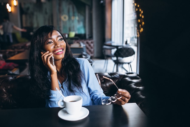 African american woman with phone in a cafe