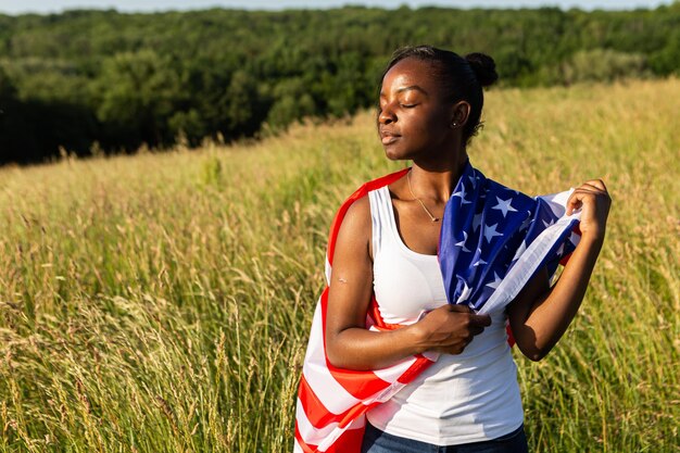 アメリカの国旗に包まれたアフリカ系アメリカ人の女性