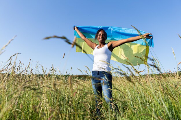 African american woman wrapped in ukrainian yellow blue flag national symbol of Ukraine