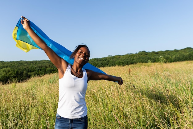 African american woman wrapped in ukrainian yellow blue flag national symbol of Ukraine