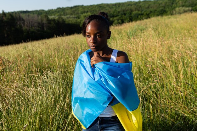 Foto donna afroamericana avvolta nel simbolo nazionale della bandiera blu gialla ucraina dell'ucraina