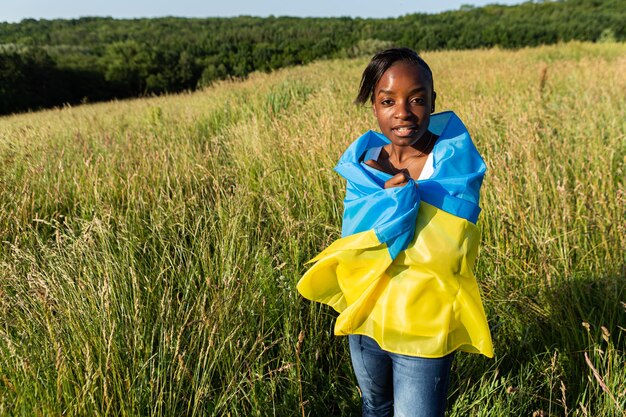 African american woman wrapped in ukrainian yellow blue flag national symbol of Ukraine