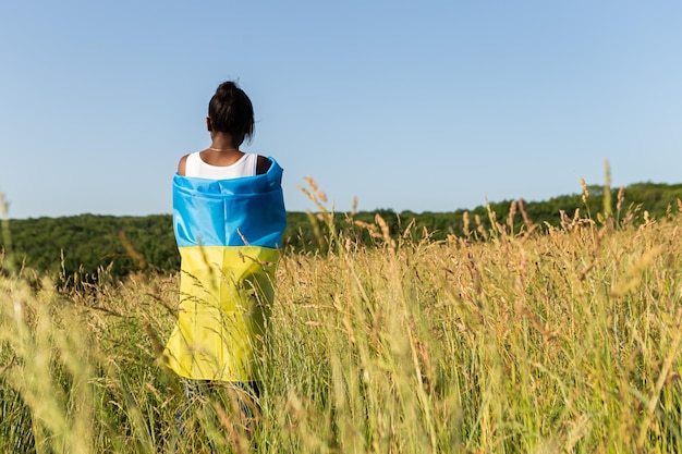 African american woman wrapped in ukrainian yellow blue flag national symbol of Ukraine