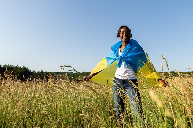 African american woman wrapped in ukrainian yellow blue flag national symbol of Ukraine