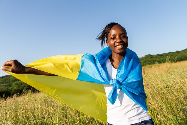 African american woman wrapped in ukrainian yellow blue flag national symbol of Ukraine