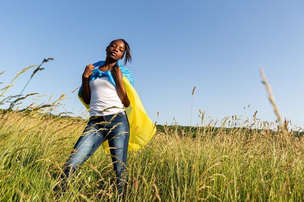 African american woman wrapped in ukrainian yellow blue flag national symbol of Ukraine