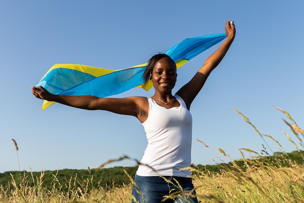 African american woman wrapped in ukrainian yellow blue flag national symbol of Ukraine