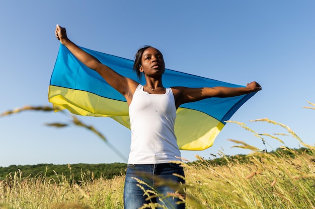 African american woman wrapped in ukrainian yellow blue flag national symbol of Ukraine