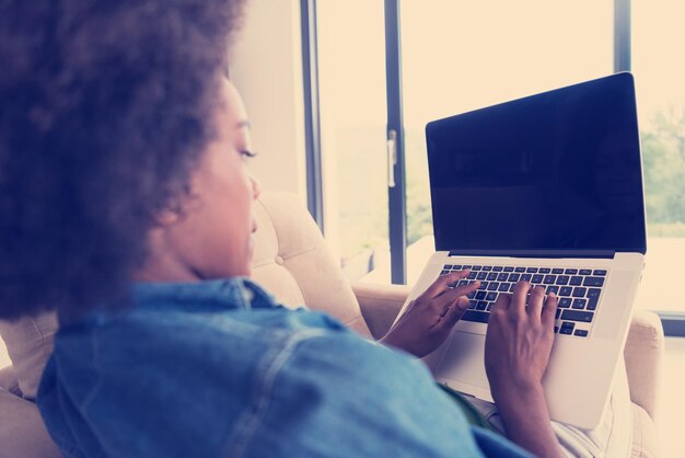 African American women at home in the chair using a laptop