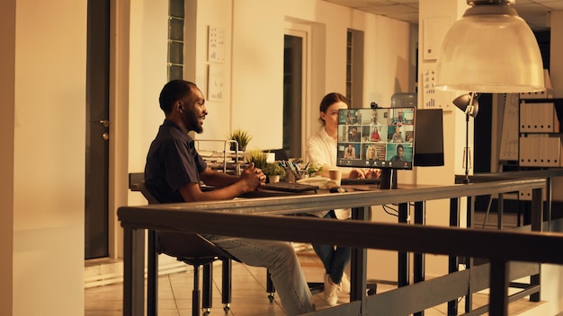 African american worker attending corporate videocall meeting,\
using computer with webcam to talk to colleagues on online\
teleconference call. talking on videoconference.