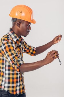 Il muratore afroamericano usa un metro a nastro