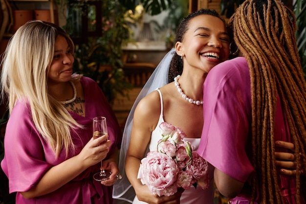 結婚パーティー中に花嫁介添人を抱きしめるアフリカ系アメリカ人の若い花嫁