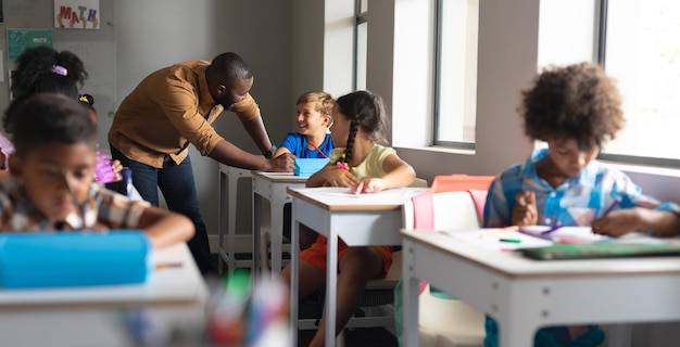 Foto giovane insegnante afroamericano che insegna a studenti multirazziali in classe